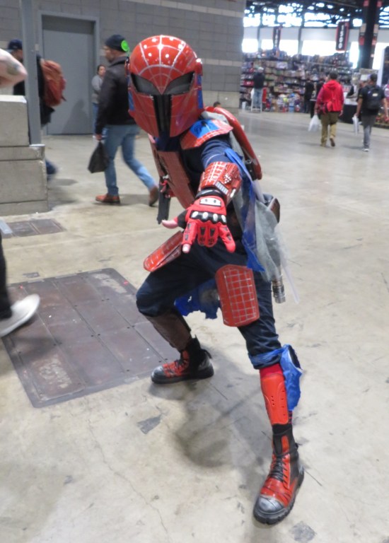 Cosplay mash-up: Mandalorian armor with red-and-blue Spider-Man webbing highlights. One gauntlet is a web-shooter.