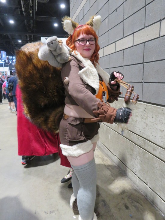 Squirrel Girl cosplayer with very big tail and slingshot.