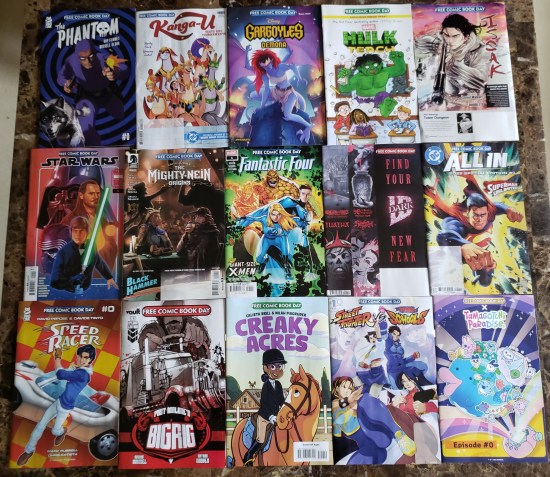 15 Free Comic Book Day comics laid side-by-side on our kitchen table.