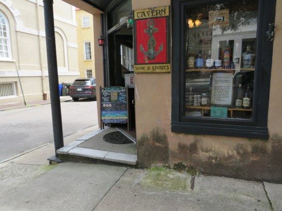 Liquor store with an old tavern sign and a sandwich chalkboard claiming it's America's Oldest Liquor Store.
