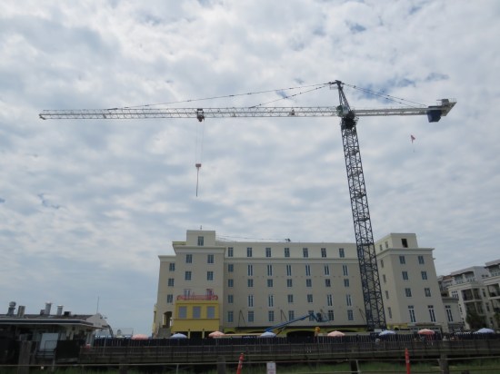 Construction crane far overhead, in front of a hotel coming soon.