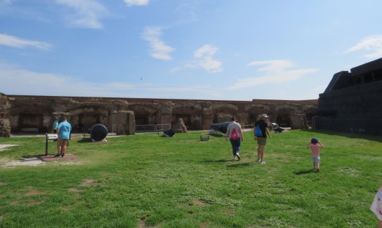 Grass field inside a fort. Alcoves line the far wall.