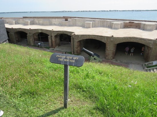 Grass hill facing fort walls, with tiny sign: "Please stay off the mounds."