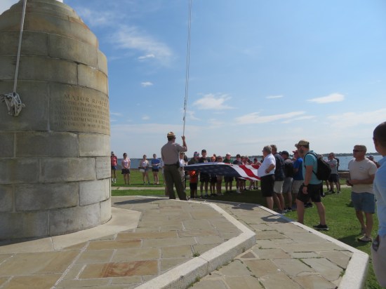 Park ranger addresses crowd on long stone steps outside brick fort.