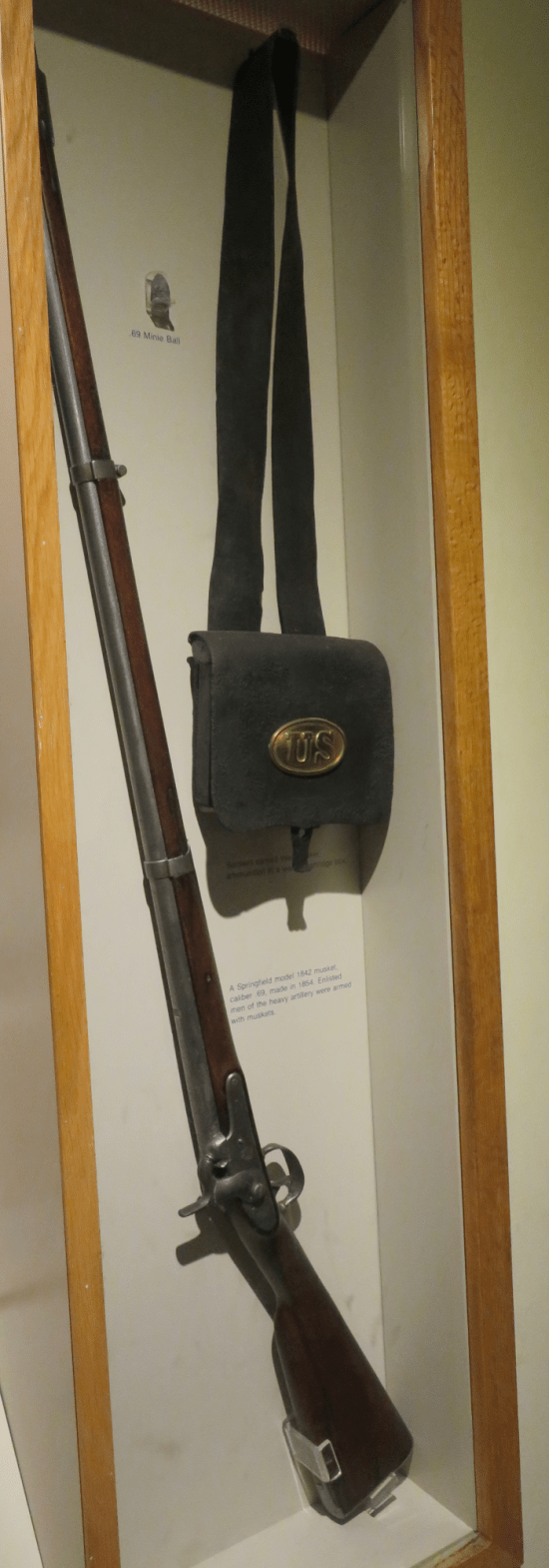 vitrine with real big rifle and black satchel.