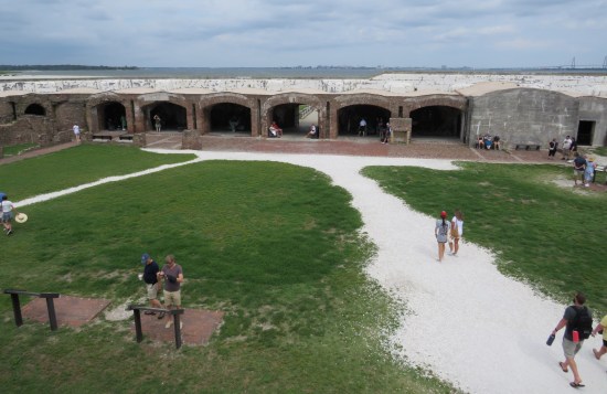 Grass in middle of fort with walkways covered in fine white gravel. Archway in far wall without doors is main entrance.
