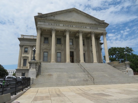US Custom House, old Greco-Roman government building with multiple columns atop at stone staircase.
