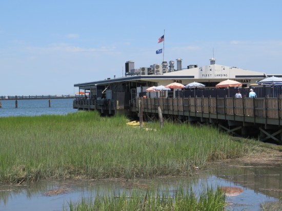 Very wet marsh with much tall grass, next to a harborside restaurant.