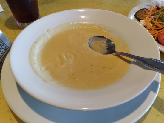 Creamy bowl of yellow soup, a bit coagulated around the rim.