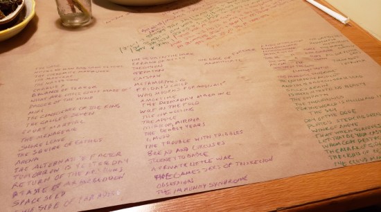 Many Trek episode titles in crayon on brown paper, on a restaurant table.