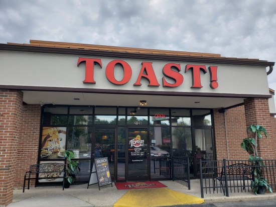 Brick strip-mall restaurant with orange logo for TOAST!