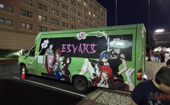 Green truck with anime characters painted on the side, parked in a hotel lot.