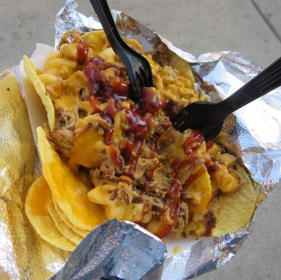 Nachos topped with pulled pork, macaroni and cheese, and a bit of barbecue sauce.