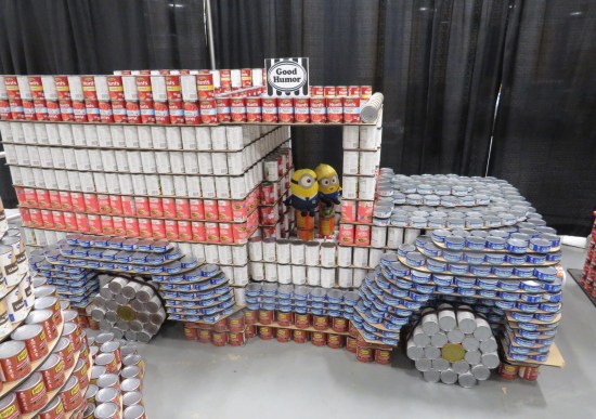 canned food sculpture of an ice cream truck, with two stuffed Minion dolls at the steering wheel.