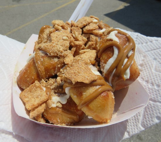 Small paper boat filled with exactly what the caption describes, but also traces of white icing mixed in.