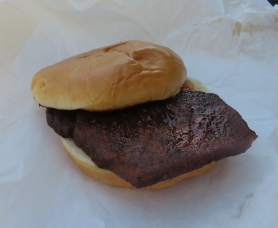 A Deep Fried Pork Chop on a plain white hamburger bun, not even a large one.