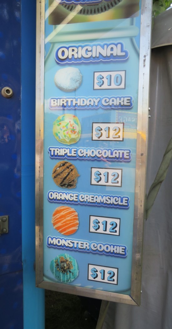 Menu sign with pcis of such fried Oreo variants as birthday cake, triple chocolate, orange Creamsicle, and monster cookie.