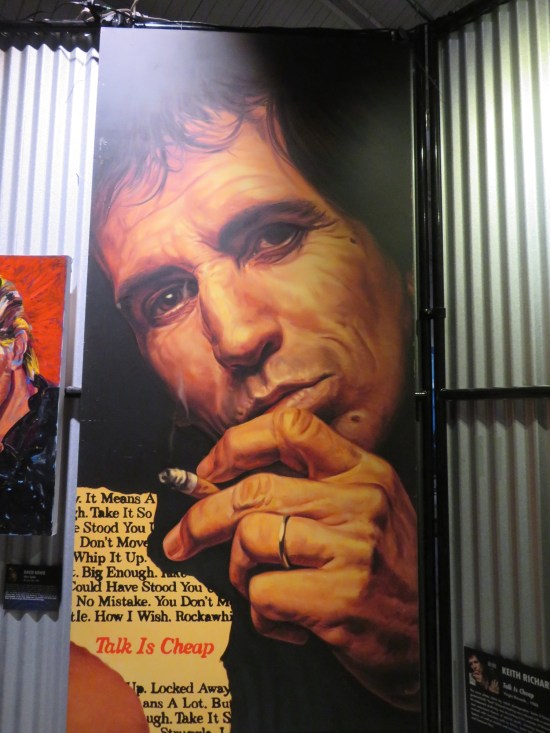 Large blown-up painting of Keith Richards who is naturally smoking.