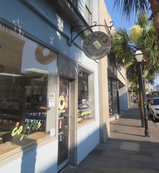 Small white donut shop on a city street, with donut signage proclaiming their name as Glazed Gourmet Doughnuts!
