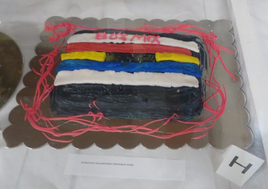 cake shaped like audiocassette. Pink icing spells "80s mix" at the top.