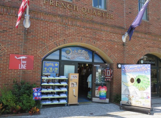 Gift shop with T-shirts outside, housed in a two-story brick building labeled "French Quarter Inn & Shops".