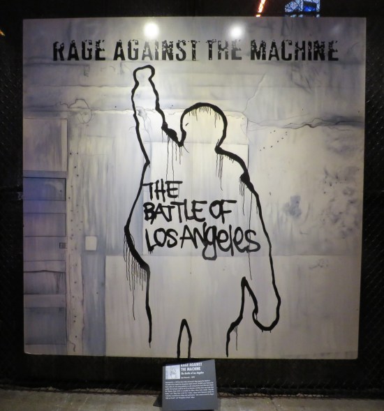 White cover with black elements including band name, title and a murder victim chalk outline raising a fist in the air.