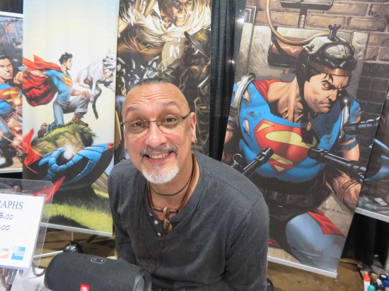 Rags Morales smiling at his table! Banners have lots of Superman art.