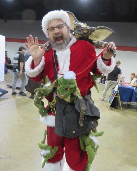 Santa-suited guy screaming while covered in Gremlin dolls.