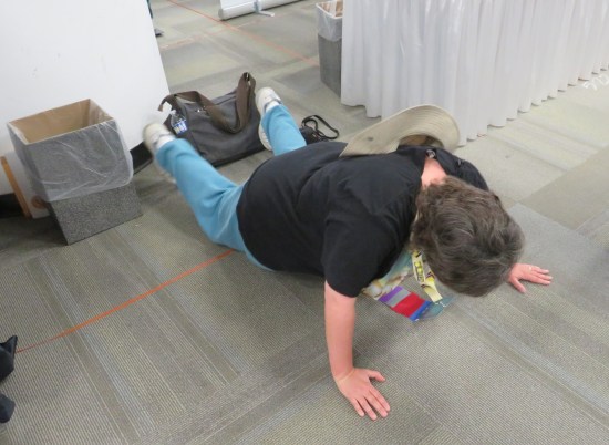 Anne doing a push-up on a concrete floor.