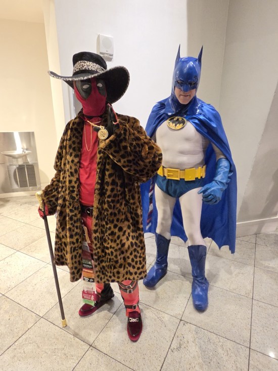 Normal Batman costume, Deadpol costume with leopard-print jacket, matching hat, cane and bling.