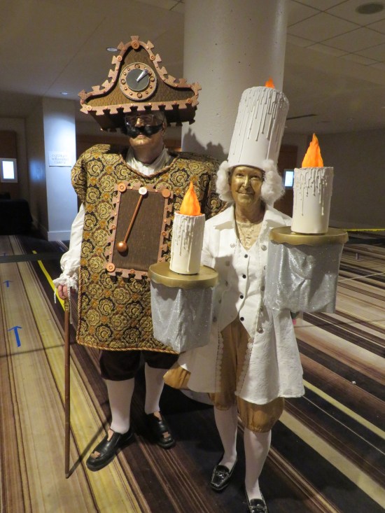 An older couple with very keen Disney costumes from "Beauty and the Beast".