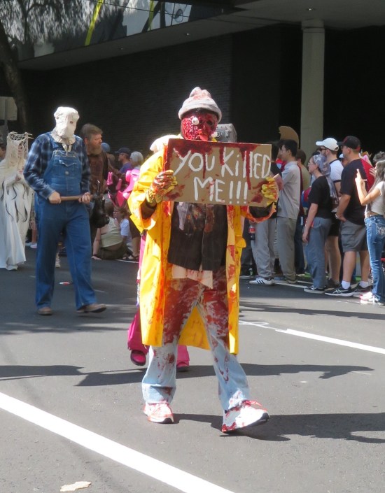 Costume: hitchhiker in yellow raincoat and winter cap, bloodied from being run over by a car.