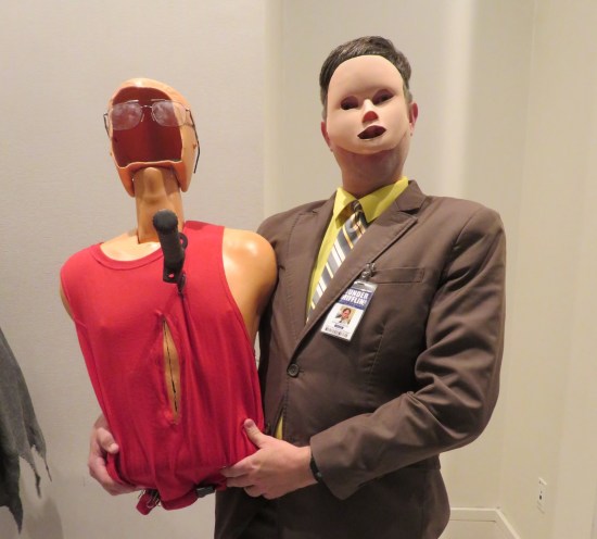 Dwight cosplayer with flesh-colored plastic on his face, holding a mangled Resusci-Annie like in The Office episode "Stress Relief Part 1".