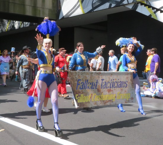 Fallout Technicians Costuming Group holding their banner. Some have Vault jumpsuits, at least two are New Vegas dancers.