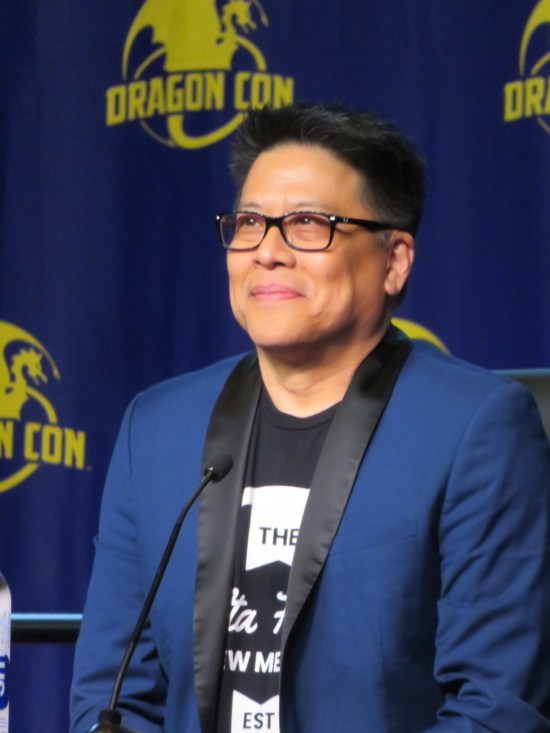 Garrett Wang in same glasses but with blue blazer and different black T-shirt.