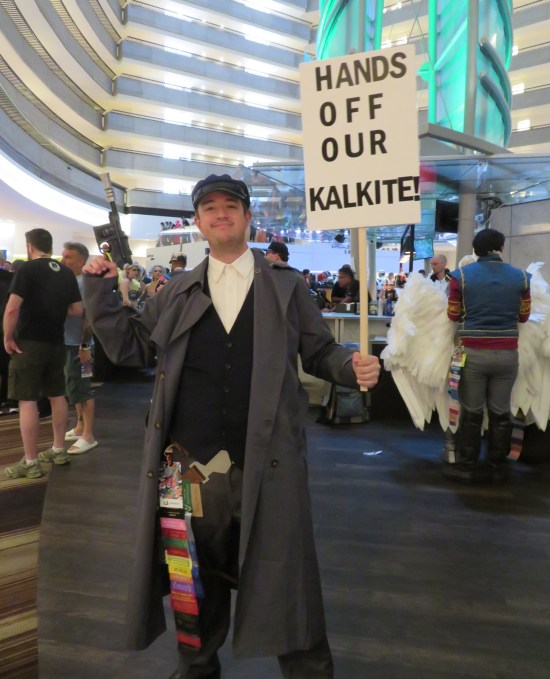 Guy in peasant costume carrying sign: "Hands off our kalkite!"