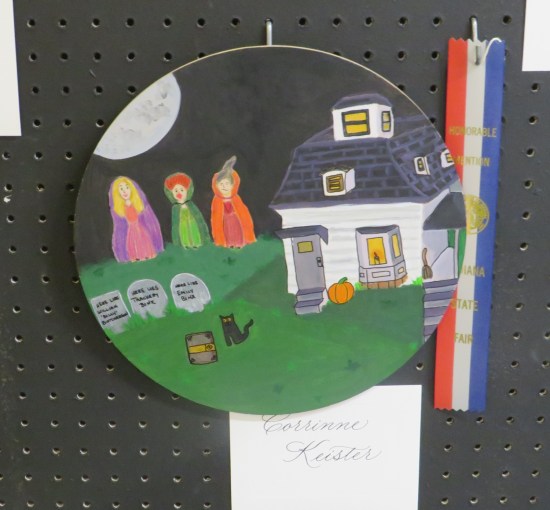 Plate with a youngster's painting of the three "Hocus Pocus" witches, their house and other related things.
