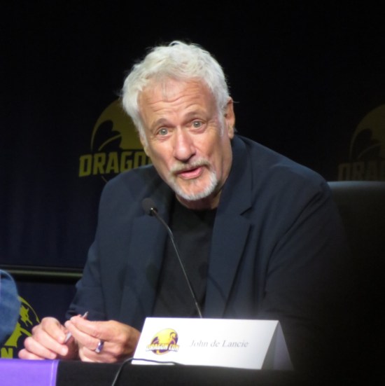 John de Lancie speaking at a Q&A stage table with name card.