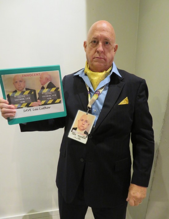 Lex Luthor costume, holding his own mugshot.