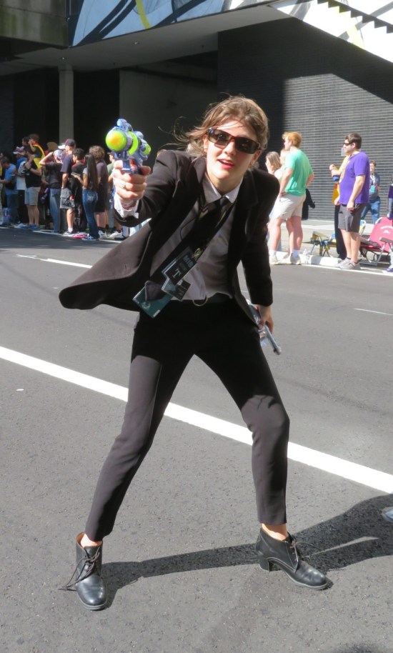 Man in Black cosplayer pointing space raygrun at us.