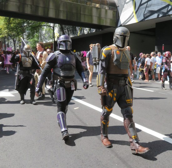 Mandalorians in purple and green-and-yellow armors.