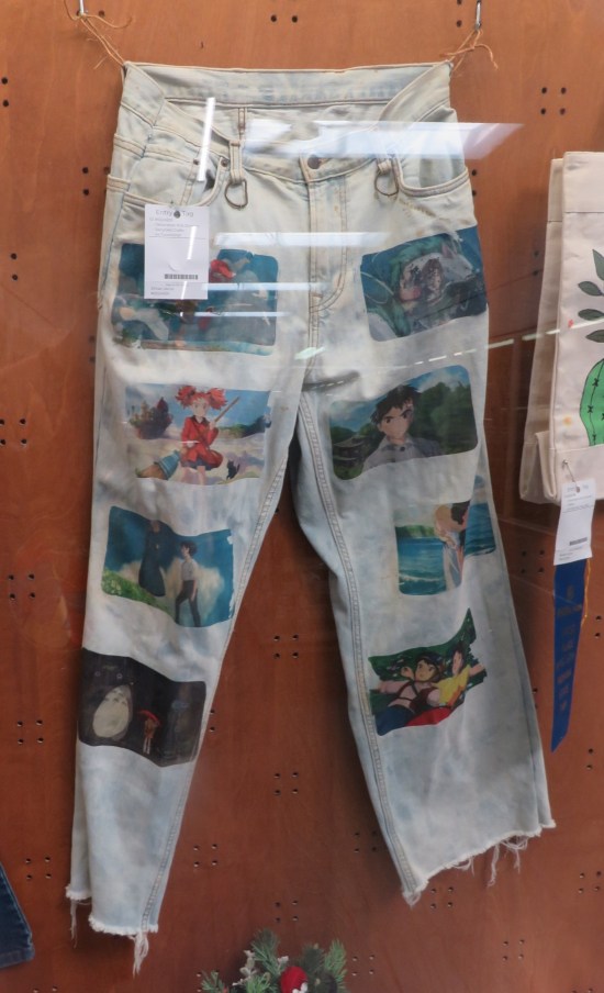 Faded light blue jeans with screen shots from eight different Miyazaki films sewn into them.