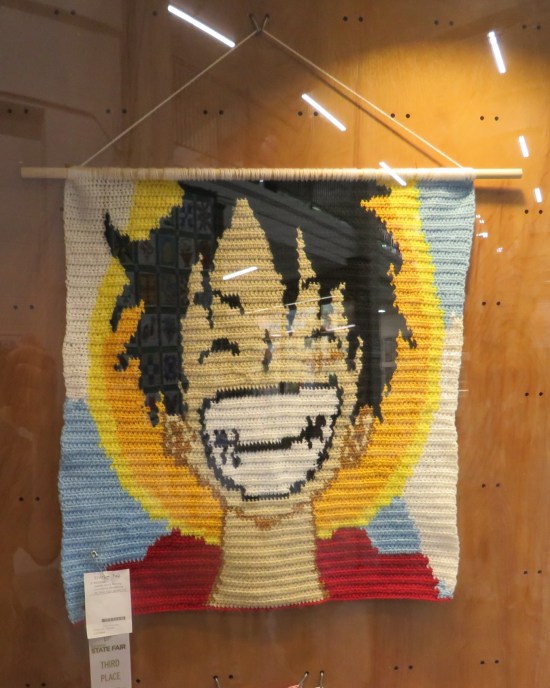 A wall hanging of a smiling Monkey D Luffy.