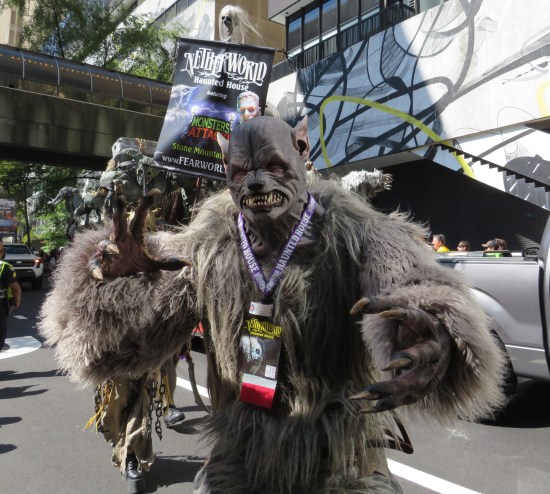 Haunted house cosplayer in all-black quasi-canine monster form.
