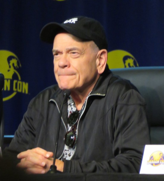 Robert Picardo at Q&A with black cap and sunglasses hanging from shirt.