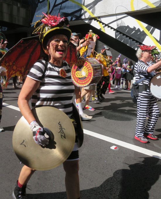 Happy Zildjian cymbalist marching in parade with Beagle Boys shirt.