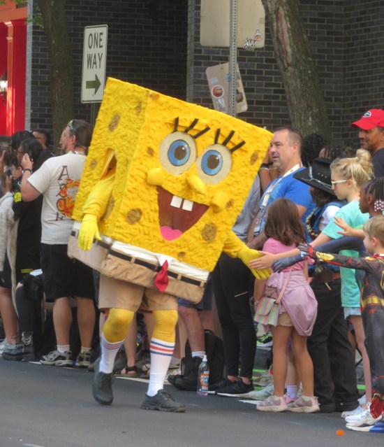 Spongebob cosplayer giving kids high-fives.