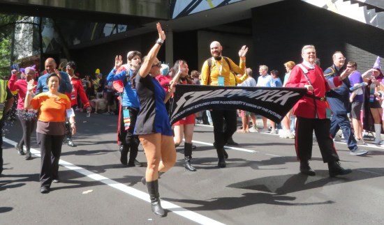 Star Trek fans marching in parade, holding a flapping banner for some Trek podcast.