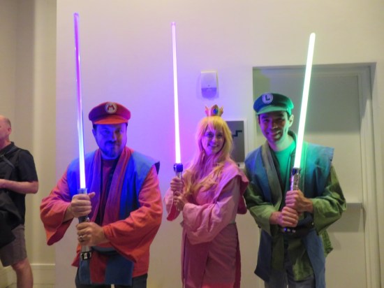 Mario, Luigi and Princess Peach costumes but done as Jedi robes and holding lit lightsabers in poor lighting.