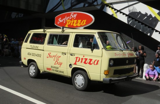 Beige VW van with Surfer Boy Pizza logos, sign, and phone number that actually belongs to Stranger Tours.